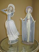 Photo showing two Lladro porcelain figurines, one in a dynamic dancing pose and the other standing tall with cape and hat.