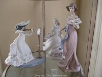 Three Lladro figurines shown together: violinist (with detached violin), maiden, and lady with flower basket.