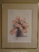 Framed print of watercolor pink tulips in vase, signed and numbered in pencil, with beige mat and gold frame visible.