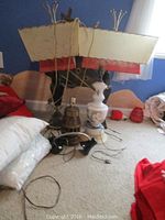 Whole group of lamps showing two large lamps with large rectangular shades, two lamp bases and cords on carpet