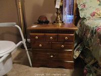 Nightstand next to bed with turtle lamp on top showing overall size and arrangement.