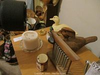 Photo showing four bird figurines of various sizes and a wooden wind chime with metal tubes.
