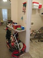 Photo of Christmas decor on and under table including tree, tins, baskets, mugs, and ornaments