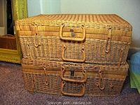 Two rattan suitcases stacked, color natural, with woven texture, handles, and metal clasps shown from front.