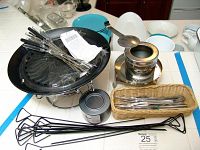 Photo showing entire fondue set including burner, tray with stand, multiple forks, skewers, and wicker basket with additional fork utensils.