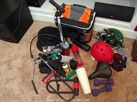 Wide view of all items including cooler, bike accessories, helmet, water bottles, gloves, paint, and binoculars