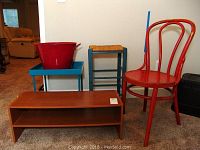 Lot showing all items together: red chair, wood shelf, blue metal table, wood stool with wicker seat, and red metal bucket.