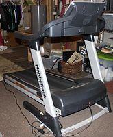 Side angle showing folded treadmill with NordicTrack logo on support frame, black plastic and silver metal construction.