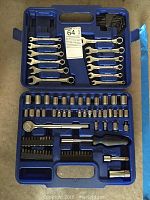 Open blue molded plastic case displaying the mechanics tool set components arranged in compartments including wrenches, sockets, bits and handles.
