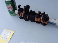Five African animal carved ebony napkin rings arranged in a line, next to a Canada Dry soda can for scale.