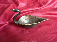 Angle view of bronze swan dish highlighting the textured body and long neck with head detail