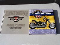 Two hardcover Harley Davidson books placed side by side. Left book is beige with gold and black logos, right book has a yellow bike illustration on the cover.