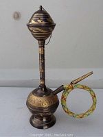 Front view of the Asian water pipe showing main vessel, neck, attached hose with metal mouthpiece.