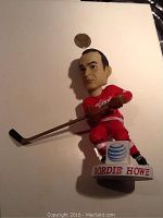 Front view of Gordie Howe bobblehead figurine featuring detailed face and red Detroit Red Wings uniform with hockey stick and base showing.