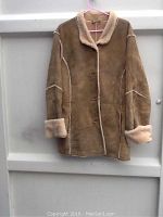 Front view of genuine sheepskin jacket showing the button closure, shearling collar, and cuffs.