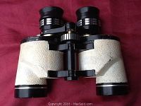 Front view of binoculars showing textured white outer casing and eyepieces.