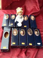 Lot of 10 boxed porcelain dolls with one doll displayed outside box with stand.
