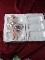 Porcelain Marilyn Monroe figurine still in protective styrofoam packaging with clear plastic wrap.