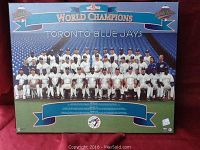 Front view of mounted picture showing the Toronto Blue Jays team posing in white uniforms with a blue background and championship banners.