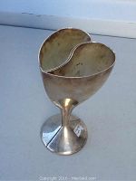 Two silverplate goblets positioned together showing heart shape from top view