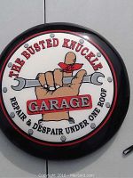 Top view of vinyl cushioned stool top with 'The Busted Knuckle Garage' logo featuring a hand holding a wrench and the text 'Repair & Despair Under One Roof'.