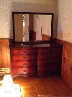 Full view of dresser and attached mirror in room setting