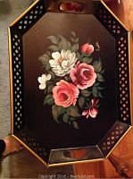 Top view of the metal tole painted tray table showing floral design and lattice edge detail