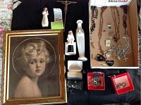 Photo showing the framed Christ Child print, white Virgin Mary praying statue, metal crucifix, several medals, and rosary beads arranged on a black surface