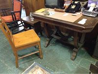 Vintage wooden table with curved legs and claw feet next to a light stained desk chair.