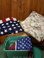 Two American flags folded, one large floral linen visible behind