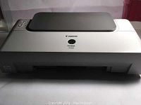 Canon Pixma iP1600 printer closed view showing white body with black top paper input tray lid closed.