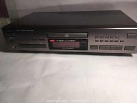 Front view of the JVC XL-V261 CD player showing control buttons, display screen, and headphone jack.