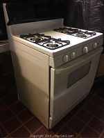 Side and front angle view of white GE gas stove showing four burners and oven door.