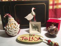 Lenox Hope Christmas dish with holly design, 'Be Jolly' cheese dish and knife, ceramic Santa Claus candle statue with box, and glass angel ornament with box set on a surface with plaid curtain background.