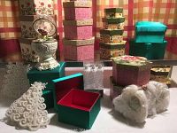 Overall view of all items showing music box, multiple stackable decorative boxes including floral and turquoise plush, Christmas tree ornaments, and rose petal soap.