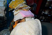 Stack of assorted colorful batik napkins and towels including pink and yellow pieces.