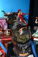 Photo showing the Vampirella snow globe with a graveyard-themed base and a figure inside the globe, along with background Marvel and Red Sonja figures.