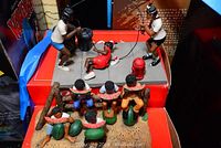 Group photo showing children playing jump rope with one child lying down and a fire hydrant on the pavement base, boxes behind them
