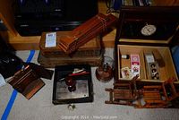 Overview of cigar presses, humidor with cards, glassed coin press, wooden rockers and bookends