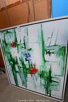 Front view of the framed abstract painting with green, red, and blue brushstrokes on white background.