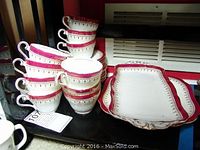Stack of white Aynsley bone china teacups featuring red and gold bands, accompanied by the larger rectangular platter beside them.