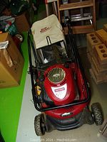 Full view of Craftsman red gas lawnmower with Dust Blocker bag and black handles, showing overall condition