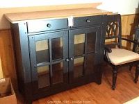 Front and partial right side view of two-tone buffet server showing two drawers and glass-paneled doors