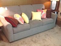 Full front view of grey Lancer sofa bed with all five throw pillows displayed