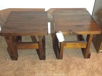 Front view of two matching pine end tables showing solid wooden construction with thick legs and cross supports.