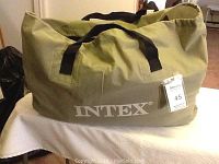 Olive green Intex branded carry tote bag with black handles containing the air mattress.