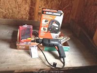 Black & Decker electric drill with drill bits and boxed jigsaw on wooden table