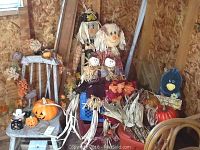 Full view of the lot featuring scarecrows, pumpkins, milk crates, and garland in a wooden shed.