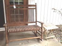 Front view of wooden double rocker bench and side table on patio