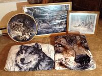 Three framed wolf prints, one round decorative plate with two wolves, two micro-fleece blankets featuring wolf faces